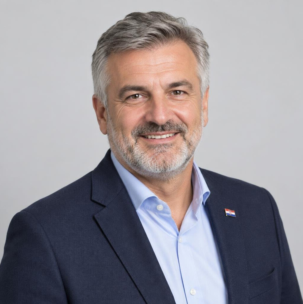 Studio portrait of a smiling Croatian man with grey hair and a beard